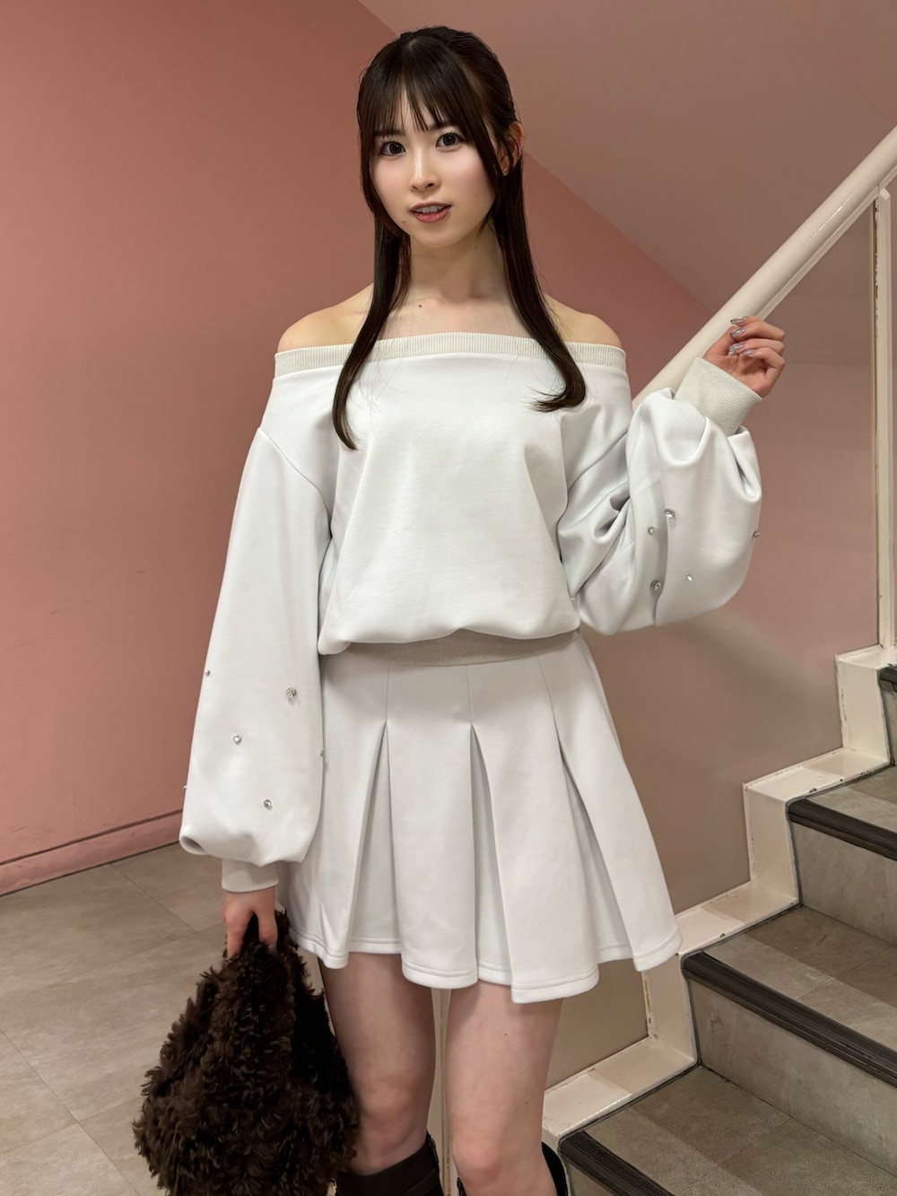 ホワイト系のスウェット、ホワイト系のスカート、ブラウン系のブーツを着用したレディースの秋コーディネートの5枚目の写真