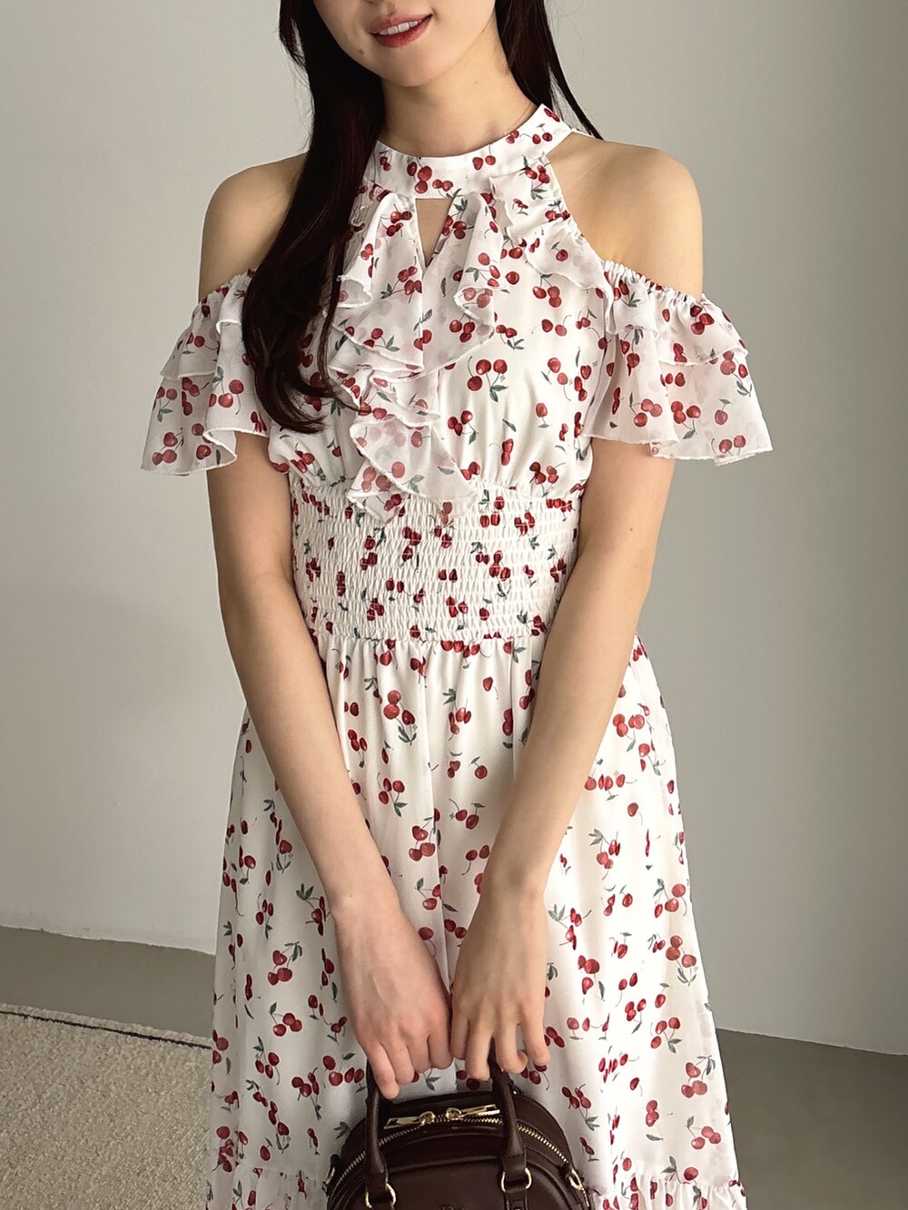 ホワイト系のワンピース、ブラウン系のハンドバッグ、ホワイト系のサンダルを着用したレディースの夏コーディネートの4枚目の写真