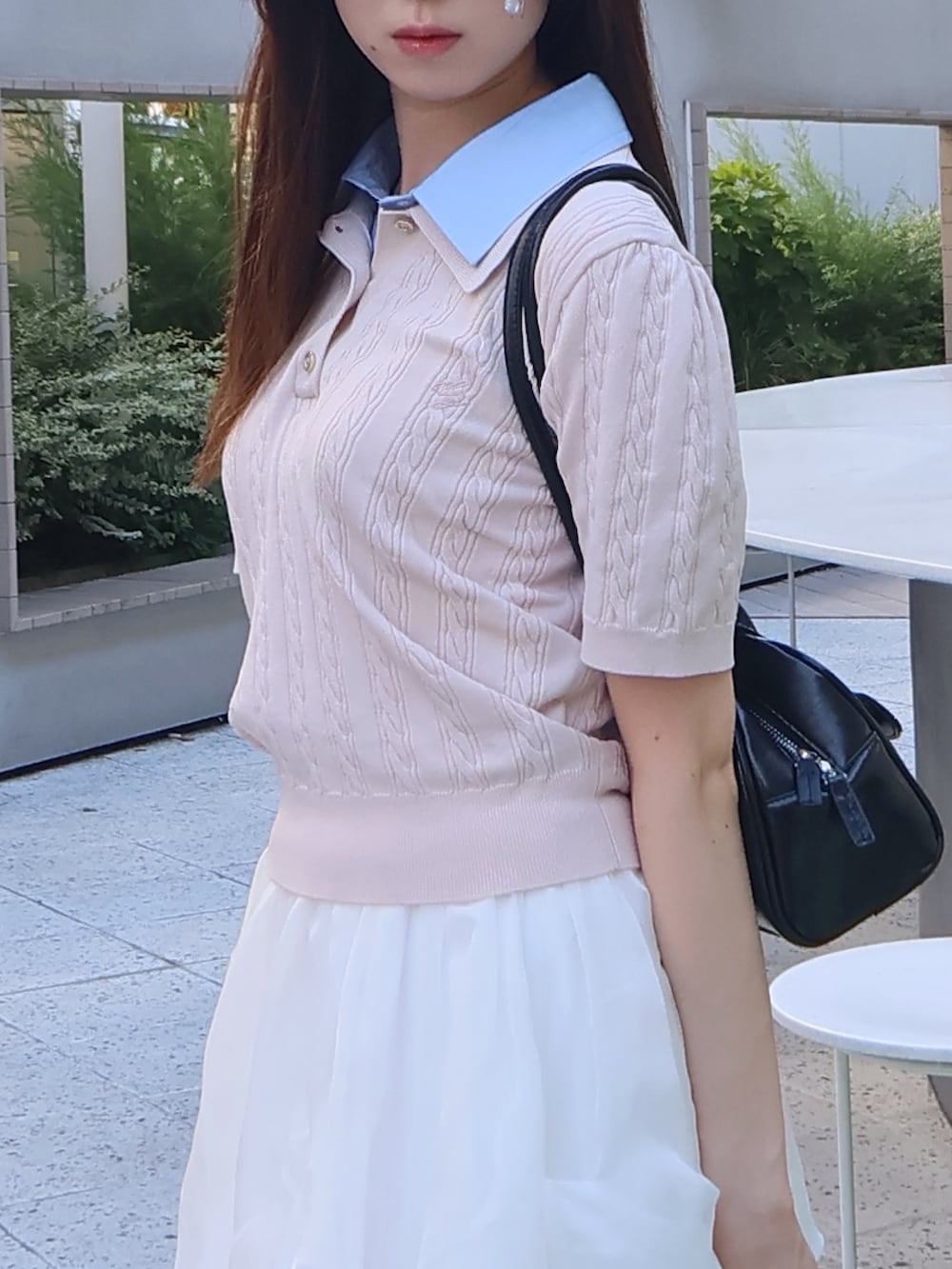 ピンク系のニット/セーター、ホワイト系のスカートを着用したレディースの夏コーディネートの4枚目の写真