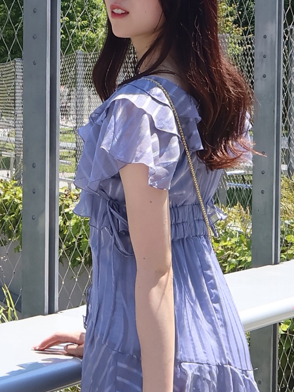 ブラウン系のサンダル、ブラウン系のハンドバッグ、ブルー系のワンピースを着用したレディースの夏コーディネートの4枚目の写真