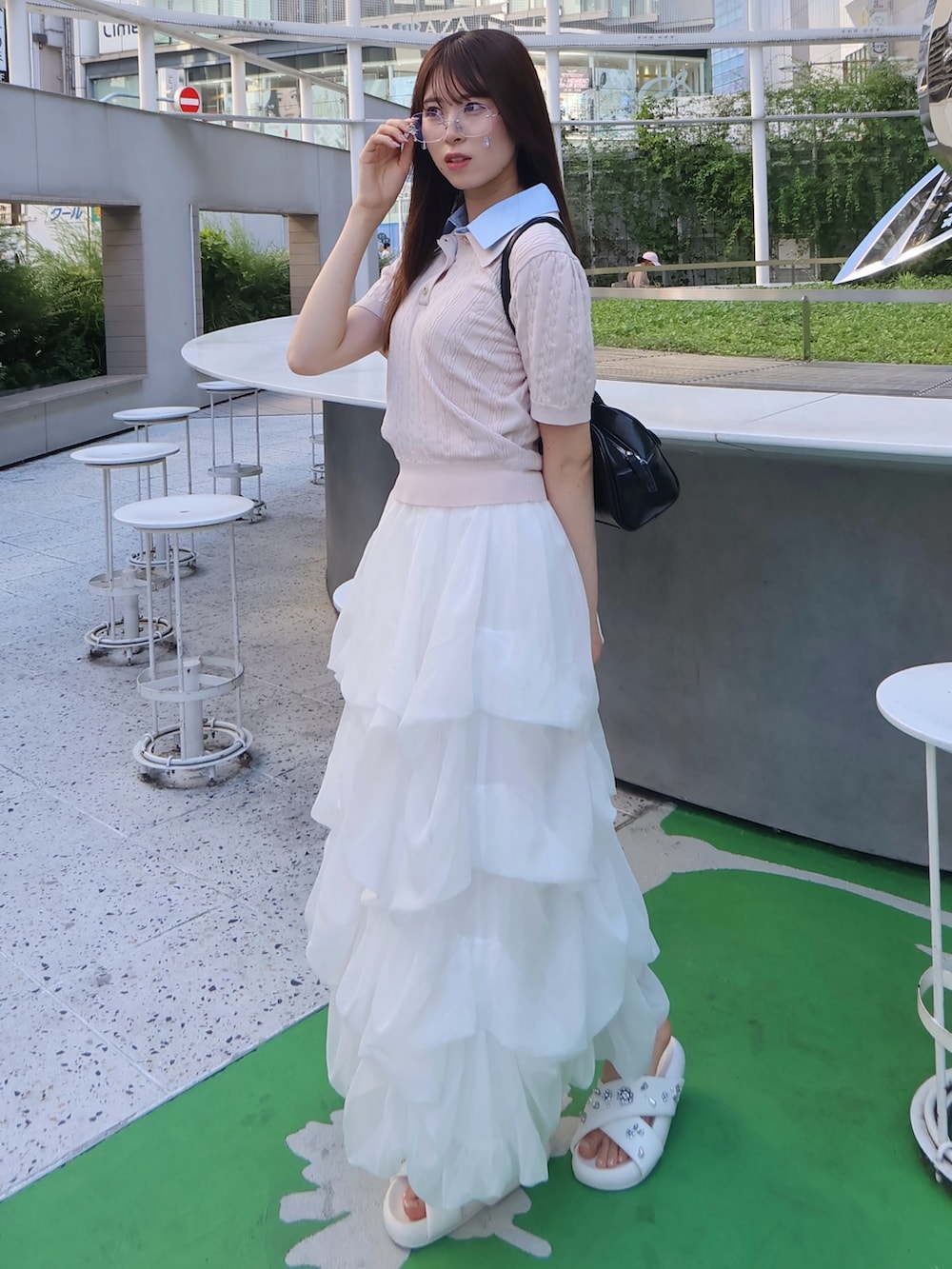 ピンク系のニット/セーター、ホワイト系のスカートを着用したレディースの夏コーディネートの2枚目の写真