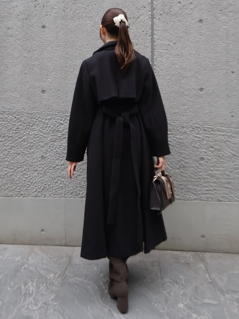 ホワイト系のニット/セーター、ブラック系のトレンチコート、その他のスカートを着用したレディースの秋コーディネートの4枚目の写真