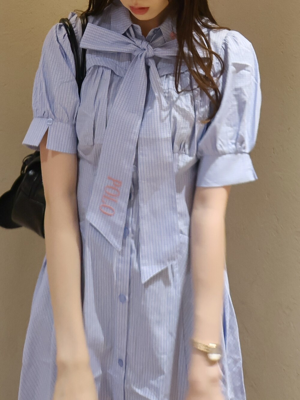 ブラック系のサンダル、ブラック系のハンドバッグ、ブルー系のワンピースを着用したレディースの夏コーディネートの7枚目の写真