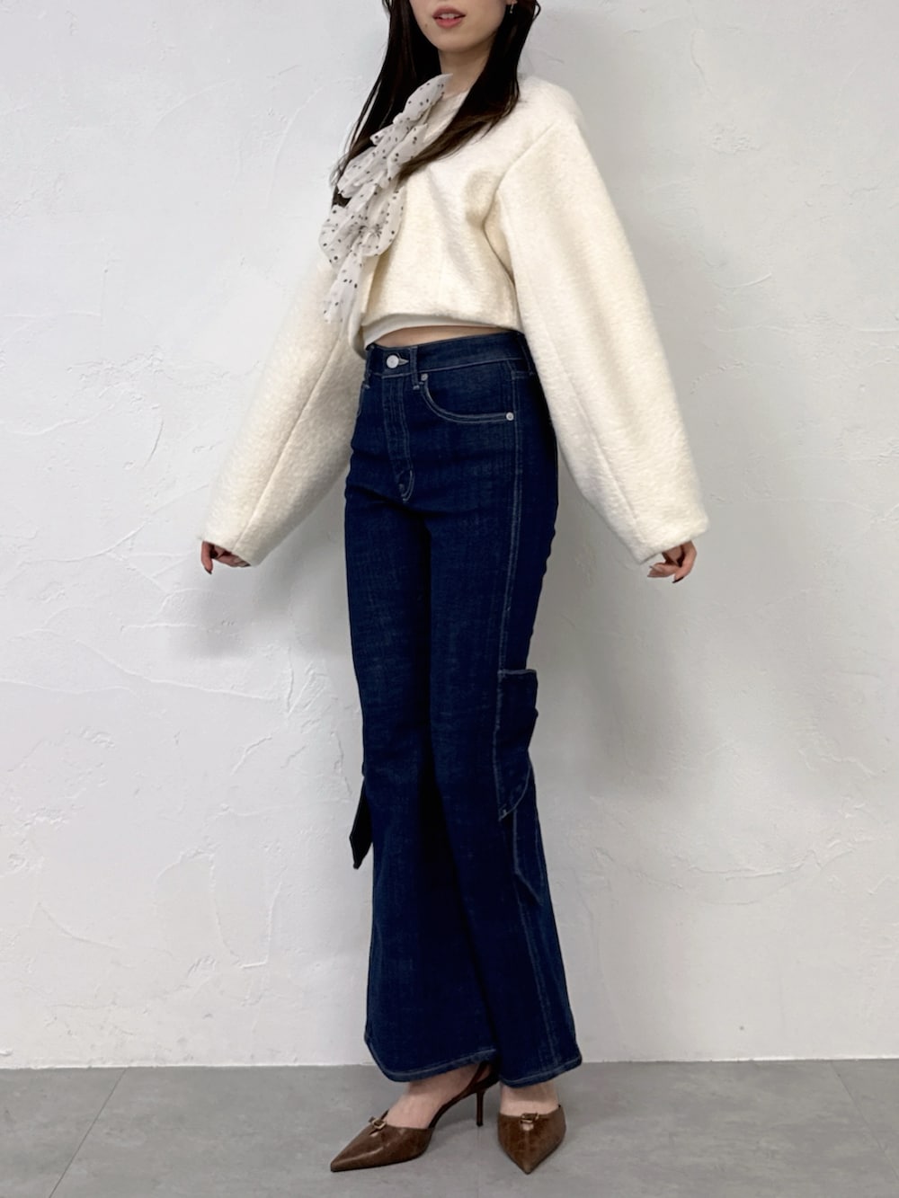 ホワイト系のブルゾン、ブルー系のデニムパンツを着用したレディースの冬コーディネートの2枚目の写真