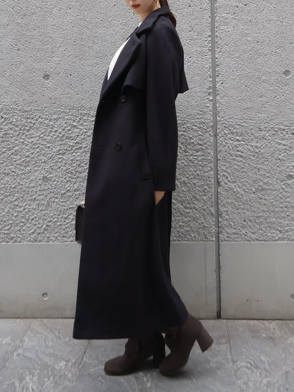 ホワイト系のニット/セーター、ブラック系のトレンチコート、その他のスカートを着用したレディースの秋コーディネートの3枚目の写真