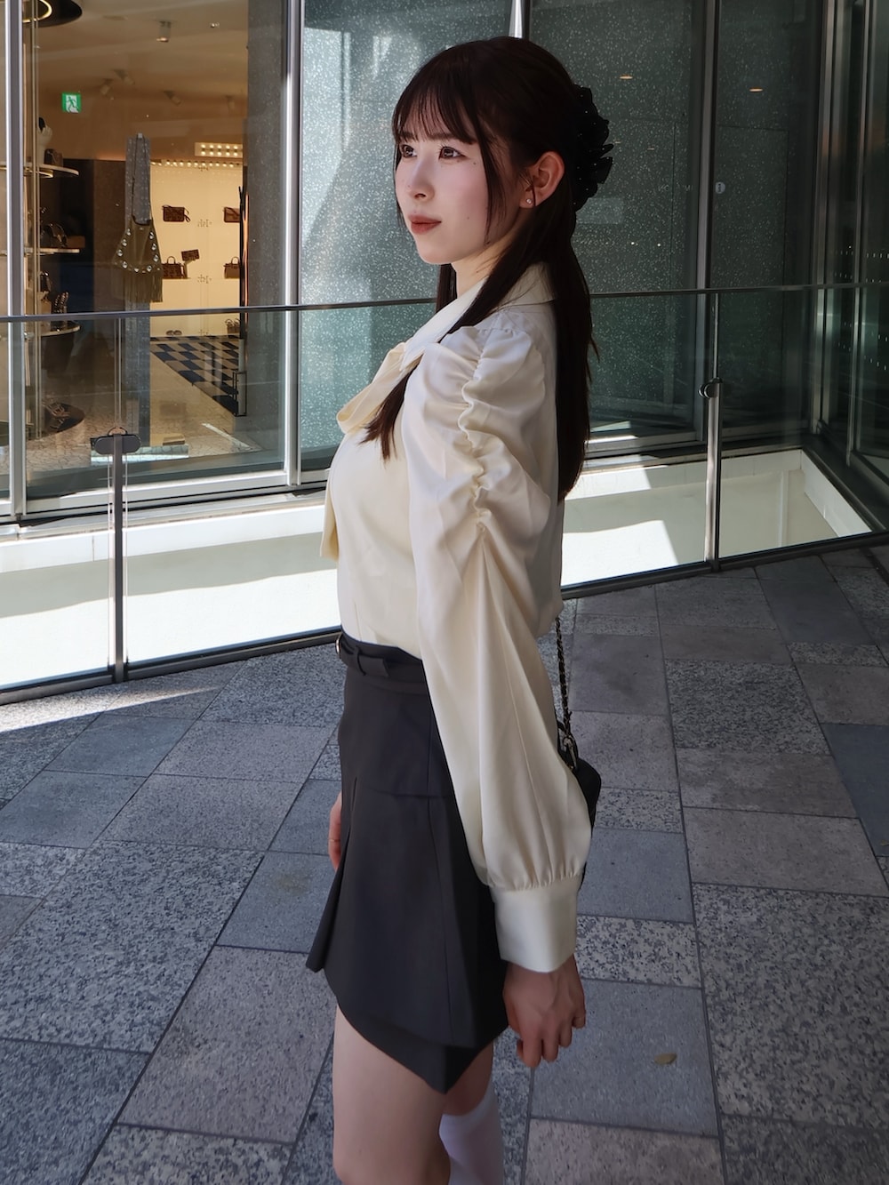 グレー系のスカート、グレー系のテーラードジャケット、イエロー系のシャツ/ブラウスを着用したレディースの秋コーディネートの7枚目の写真