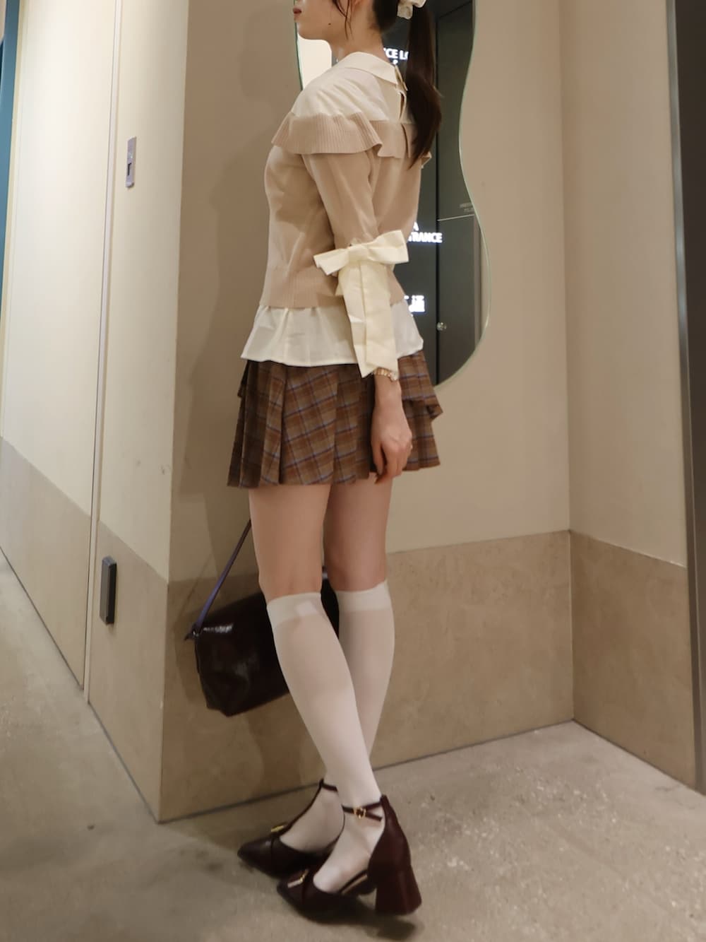 ベージュ系のニット/セーター、ブラウン系のスカート、レッド系のパンプスを着用したレディースの秋コーディネートの2枚目の写真