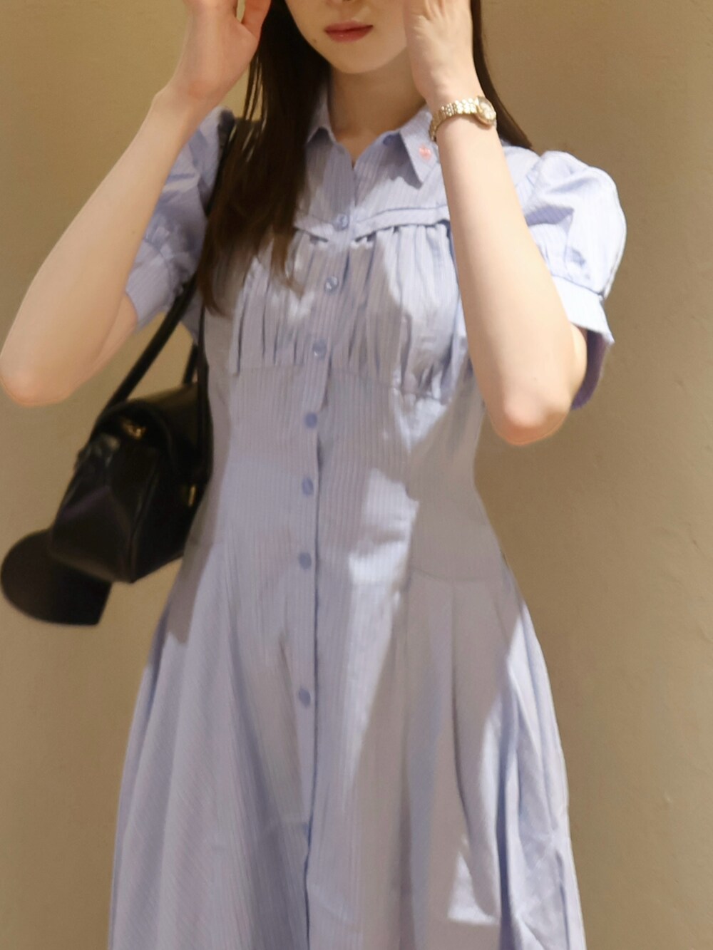 ブラック系のサンダル、ブラック系のハンドバッグ、ブルー系のワンピースを着用したレディースの夏コーディネートの6枚目の写真