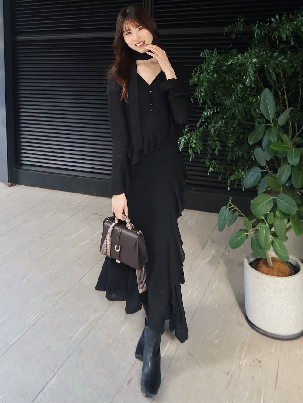 ホワイト系のその他アウター、ブラック系のワンピース、ブラウン系のショルダーバッグを着用したレディースの冬コーディネートの4枚目の写真