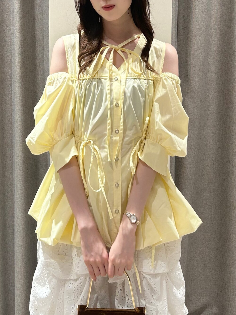 イエロー系のシャツ/ブラウス、ホワイト系のスカート、ブラウン系のサンダルを着用したレディースの夏コーディネートの3枚目の写真