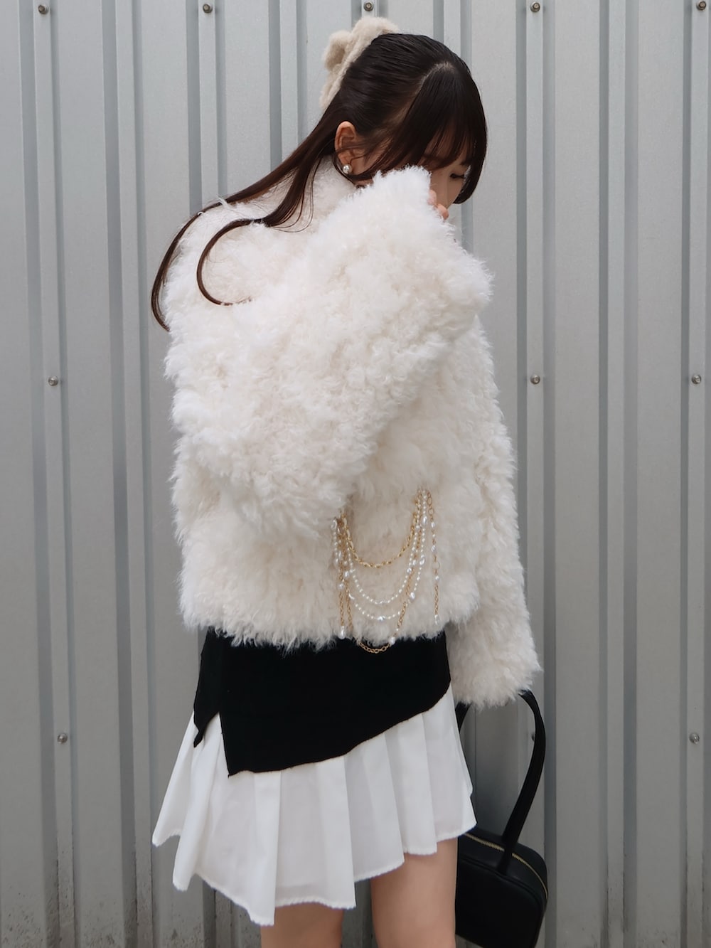 ブラック系のパンプス、ブラック系のハンドバッグ、ホワイト系のブルゾンを着用したレディースの秋コーディネートの5枚目の写真