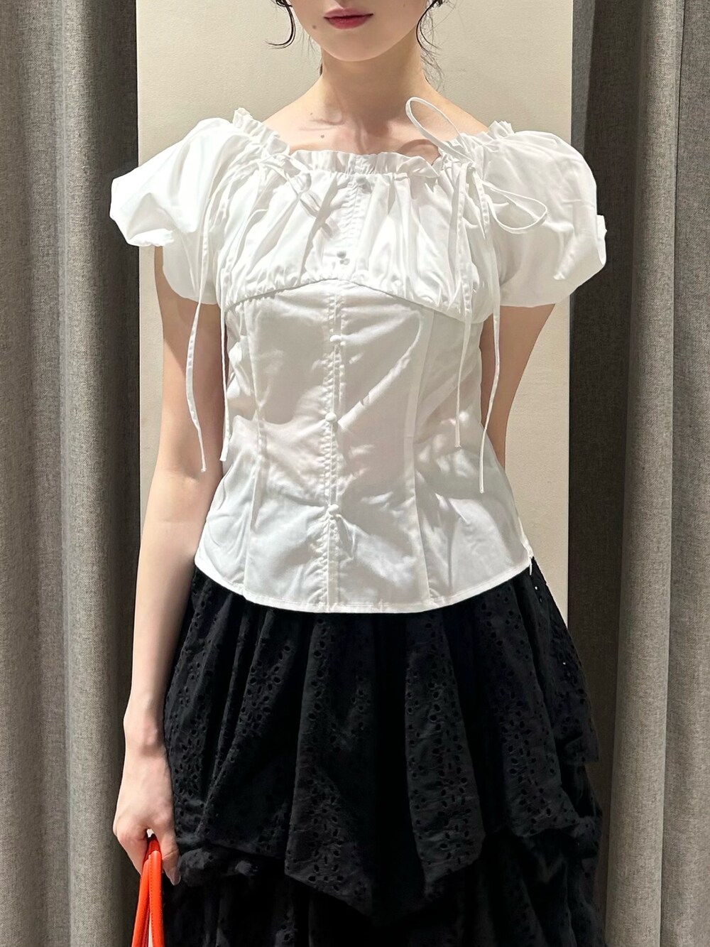 ブラック系のスカート、ブラック系のサンダル、オレンジ系のボストンバッグを着用したレディースの夏コーディネートの5枚目の写真