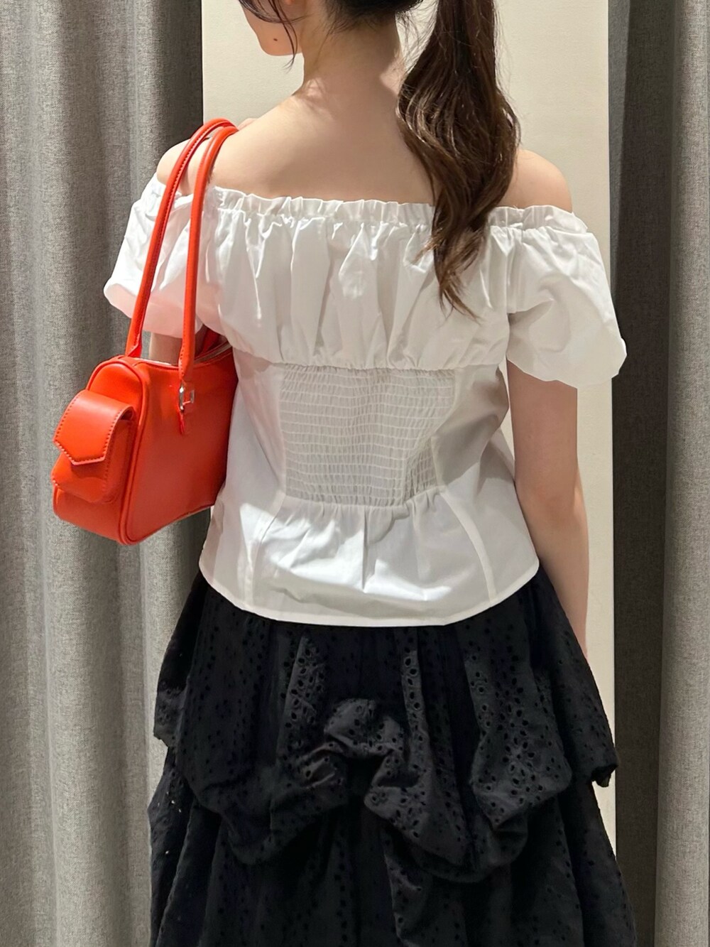 ブラック系のスカート、ブラック系のサンダル、オレンジ系のボストンバッグを着用したレディースの夏コーディネートの8枚目の写真