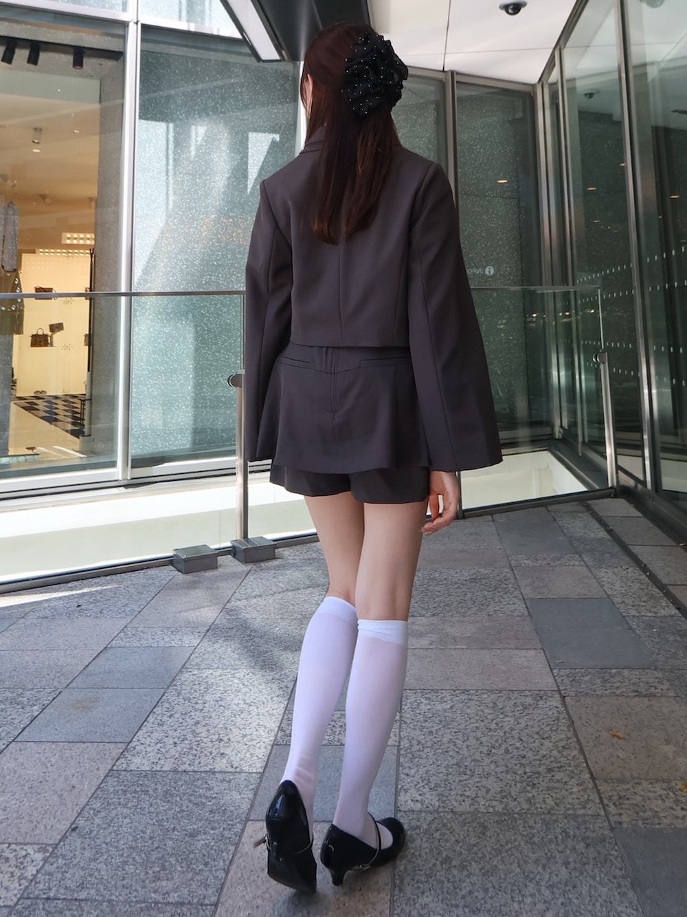 グレー系のスカート、グレー系のテーラードジャケット、イエロー系のシャツ/ブラウスを着用したレディースの秋コーディネートの3枚目の写真