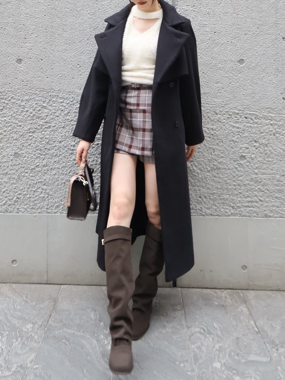 ホワイト系のニット/セーター、ブラック系のトレンチコート、その他のスカートを着用したレディースの秋コーディネートの2枚目の写真