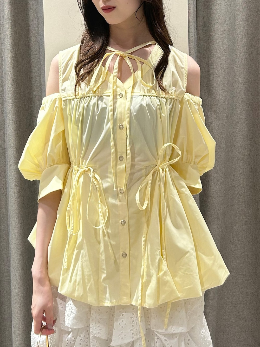 イエロー系のシャツ/ブラウス、ホワイト系のスカート、ブラウン系のサンダルを着用したレディースの夏コーディネートの4枚目の写真