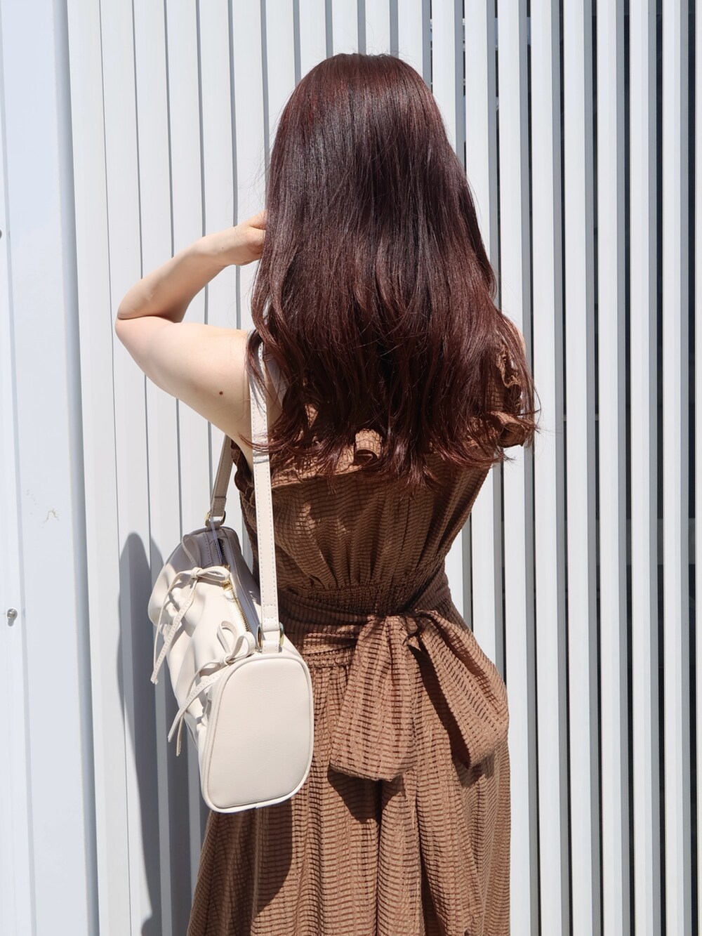 ブラウン系のワンピース、ホワイト系のサンダル、ホワイト系のハンドバッグを着用したレディースの夏コーディネートの5枚目の写真