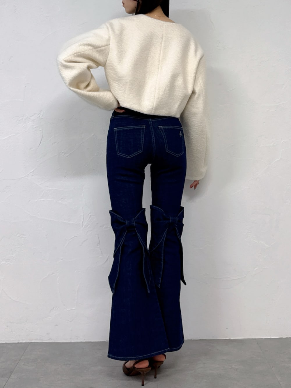 ホワイト系のブルゾン、ブルー系のデニムパンツを着用したレディースの冬コーディネートの3枚目の写真