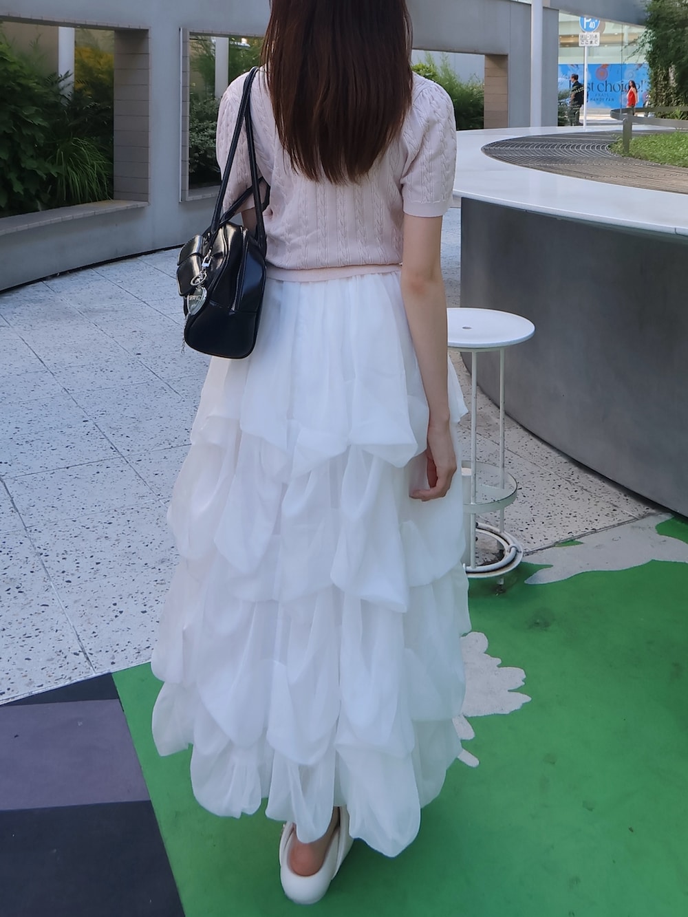 ピンク系のニット/セーター、ホワイト系のスカートを着用したレディースの夏コーディネートの3枚目の写真