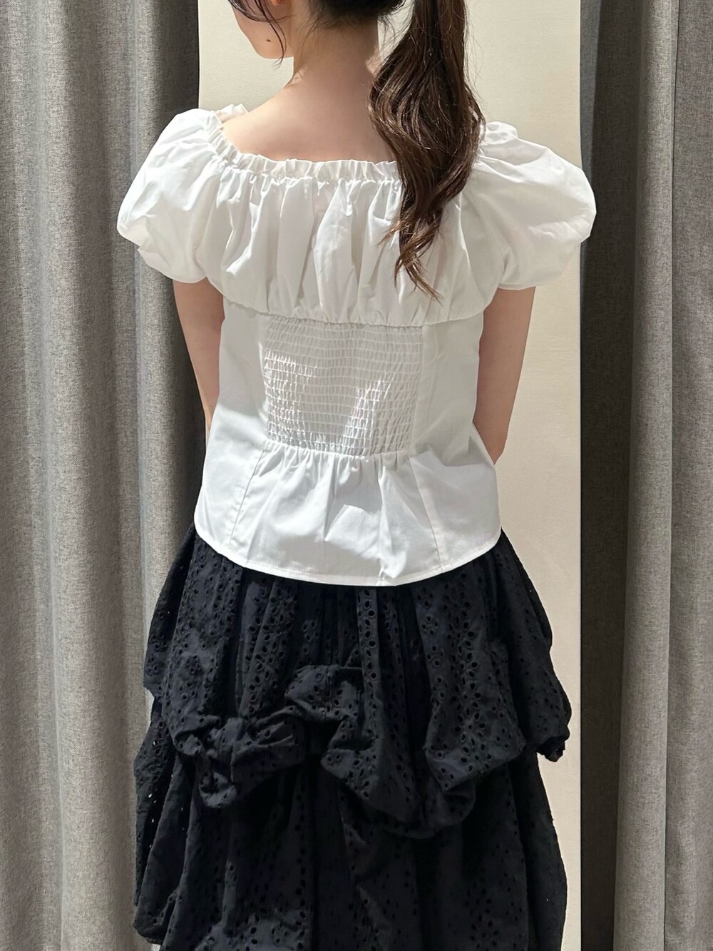 ブラック系のスカート、ブラック系のサンダル、オレンジ系のボストンバッグを着用したレディースの夏コーディネートの6枚目の写真