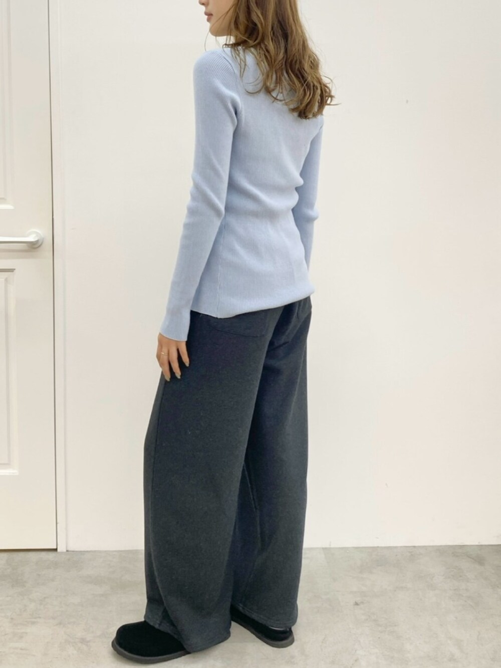 ブルー系のニット/セーター、グレー系のスウェットパンツ、ブラック系のスリッポンを着用したレディースの秋コーディネートの2枚目の写真