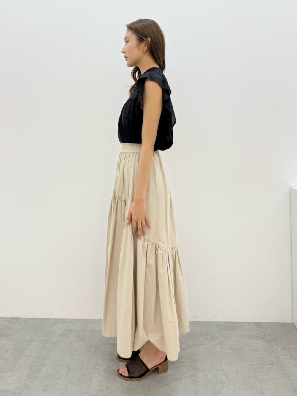 ホワイト系のスカート、ブラック系のシャツ/ブラウスを着用したレディースの夏コーディネートの4枚目の写真