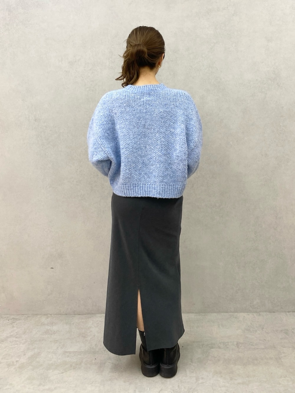 ブルー系のニット/セーター、グレー系のスカートを着用したレディースの秋コーディネートの3枚目の写真