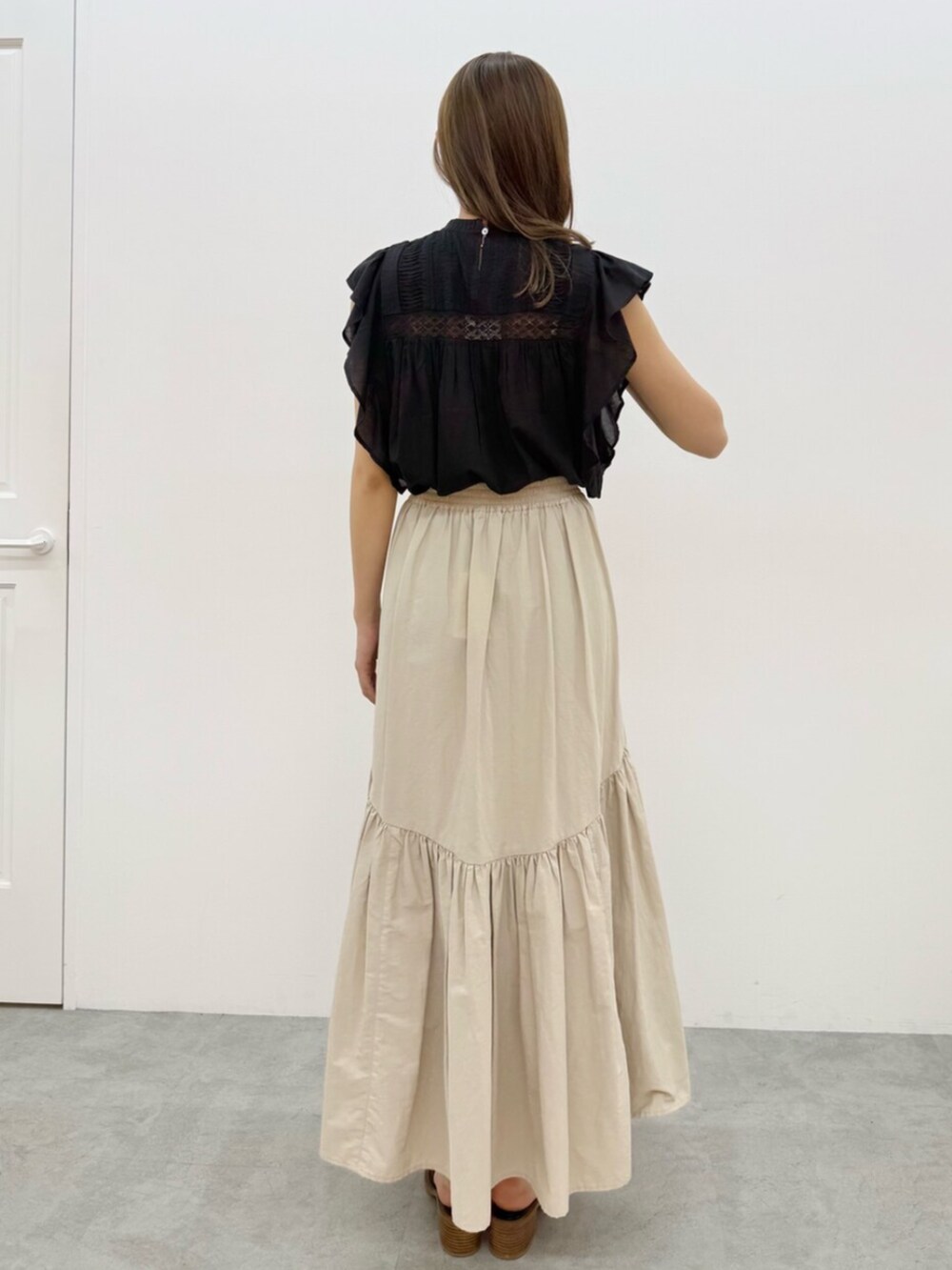 ホワイト系のスカート、ブラック系のシャツ/ブラウスを着用したレディースの夏コーディネートの5枚目の写真