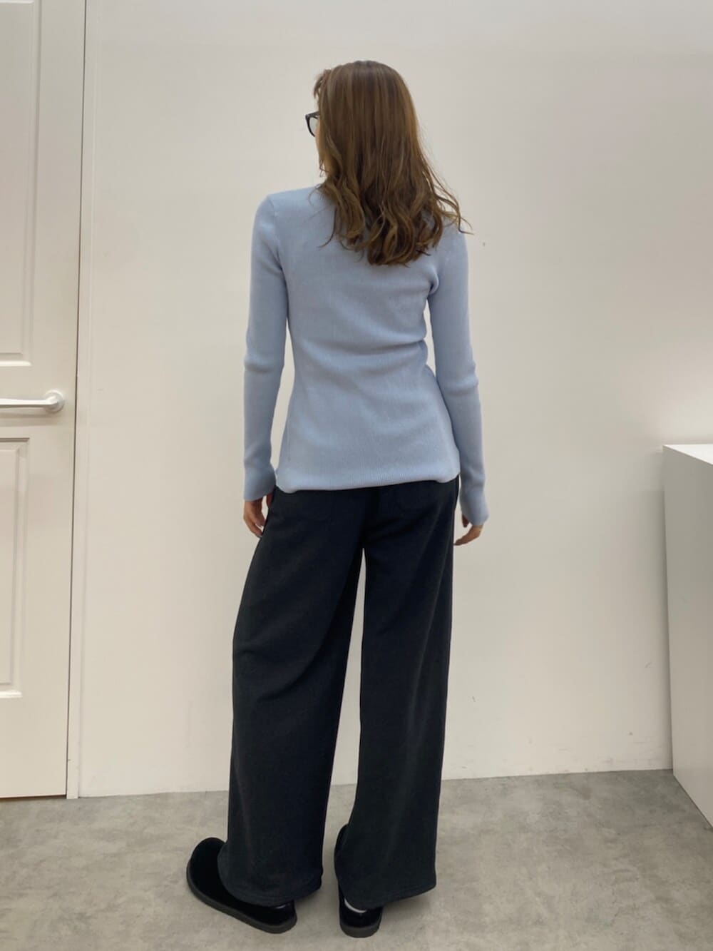 ブルー系のニット/セーター、グレー系のスウェットパンツ、ブラック系のスリッポンを着用したレディースの秋コーディネートの4枚目の写真