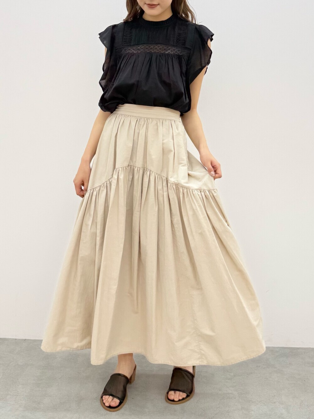 ホワイト系のスカート、ブラック系のシャツ/ブラウスを着用したレディースの夏コーディネートの3枚目の写真