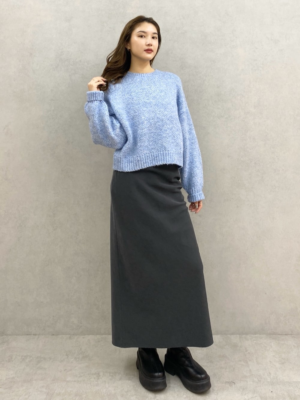 ブルー系のニット/セーター、グレー系のスカートを着用したレディースの秋コーディネートの4枚目の写真