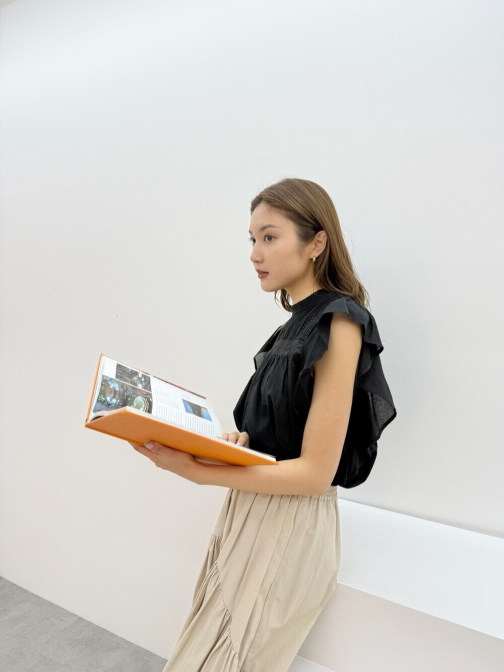 ホワイト系のスカート、ブラック系のシャツ/ブラウスを着用したレディースの夏コーディネートの2枚目の写真