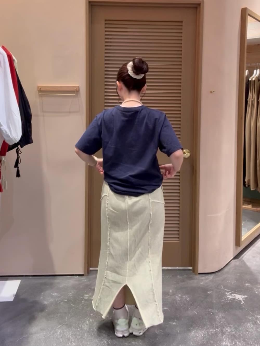 ブルー系のTシャツ/カットソー、イエロー系のスカート、ホワイト系のスニーカーを着用したレディースの秋コーディネートの3枚目の写真