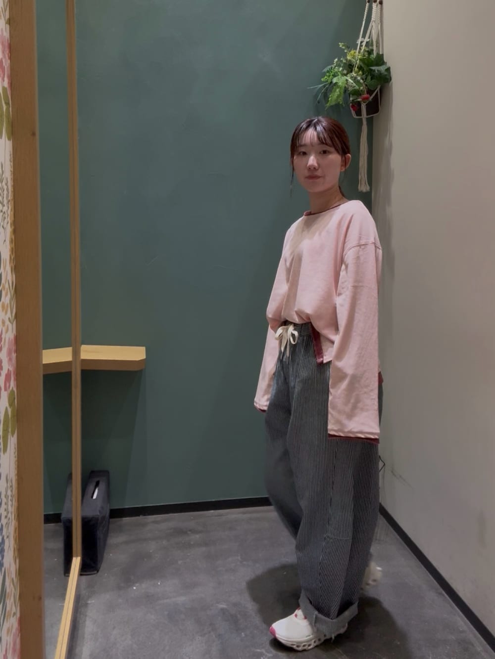 ホワイト系のスニーカー、ピンク系のTシャツ/カットソー、ブルー系のデニムパンツを着用したレディースの秋コーディネートの3枚目の写真