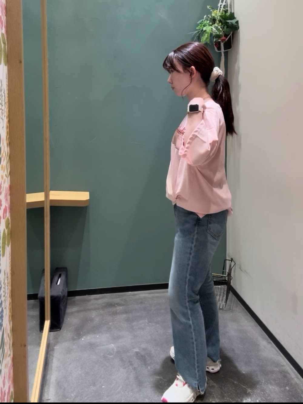 ブルー系のデニムパンツ、ホワイト系のスニーカー、ピンク系のTシャツ/カットソーを着用したレディースの秋コーディネートの2枚目の写真
