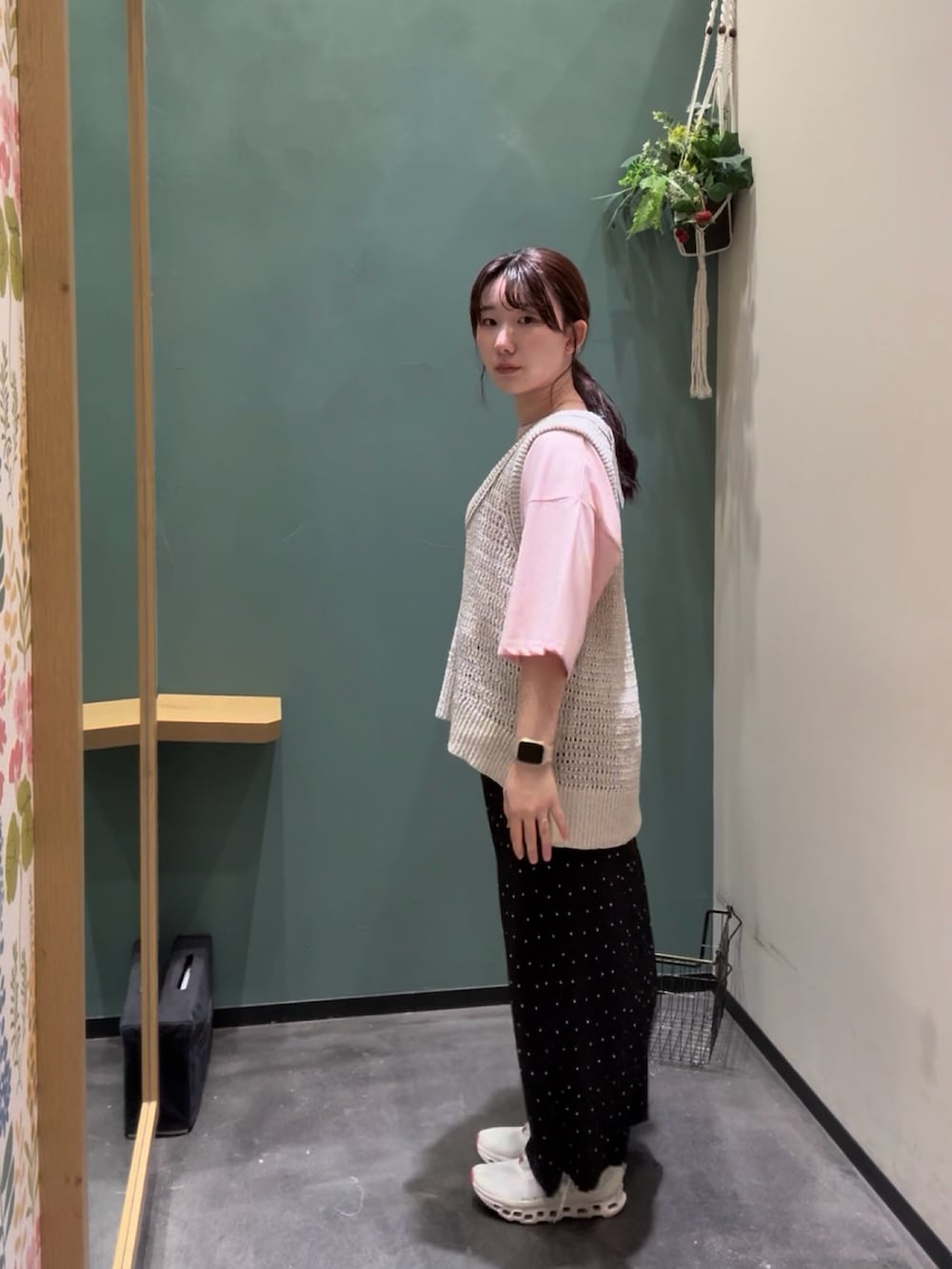 ホワイト系のベスト、ピンク系のTシャツ/カットソー、ブラック系のスカートを着用したレディースの秋コーディネートの2枚目の写真