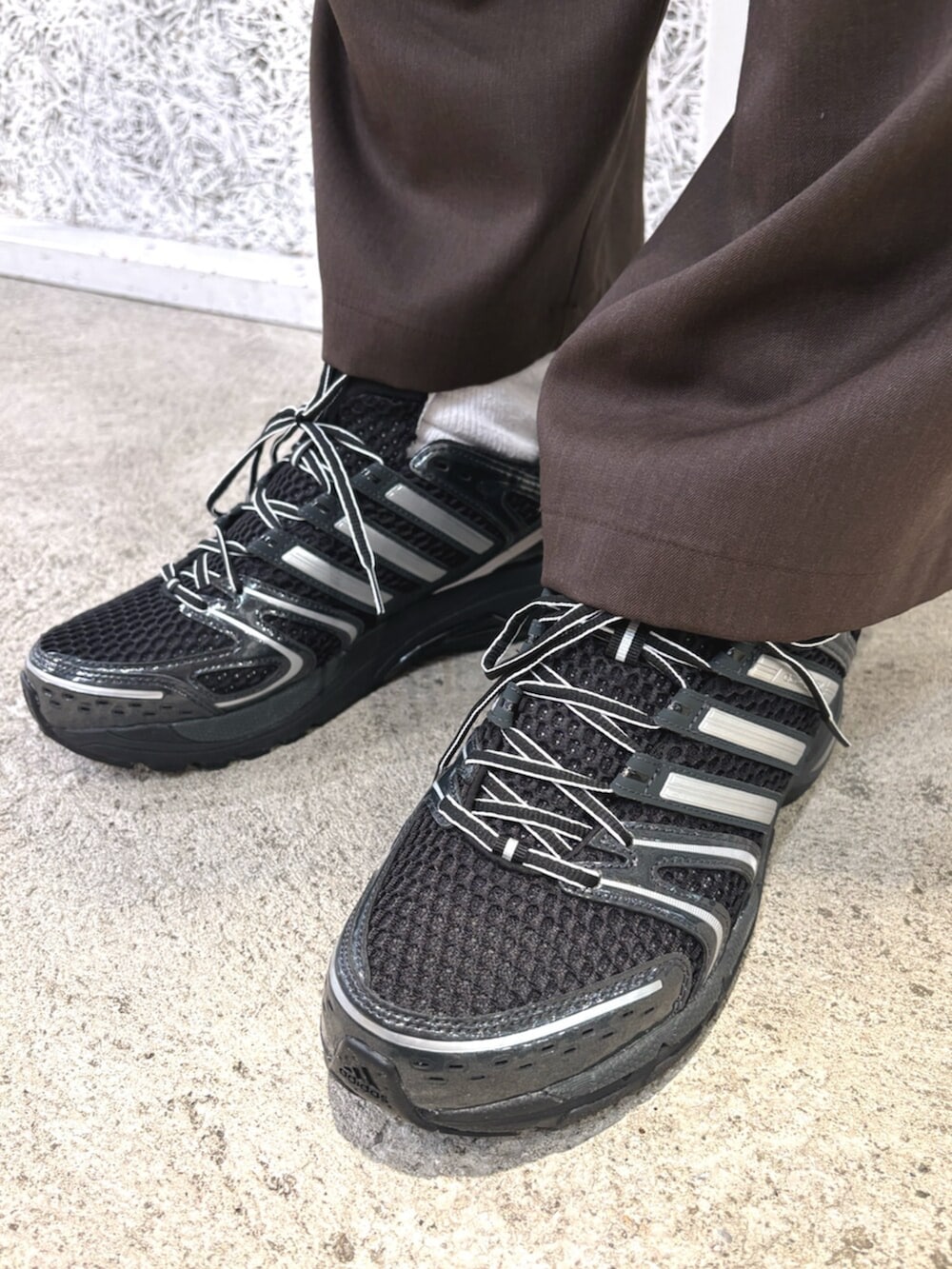 イエロー系のブルゾン、ブラック系のスニーカー、ブラック系のアクセサリーを着用したメンズの冬コーディネートの4枚目の写真