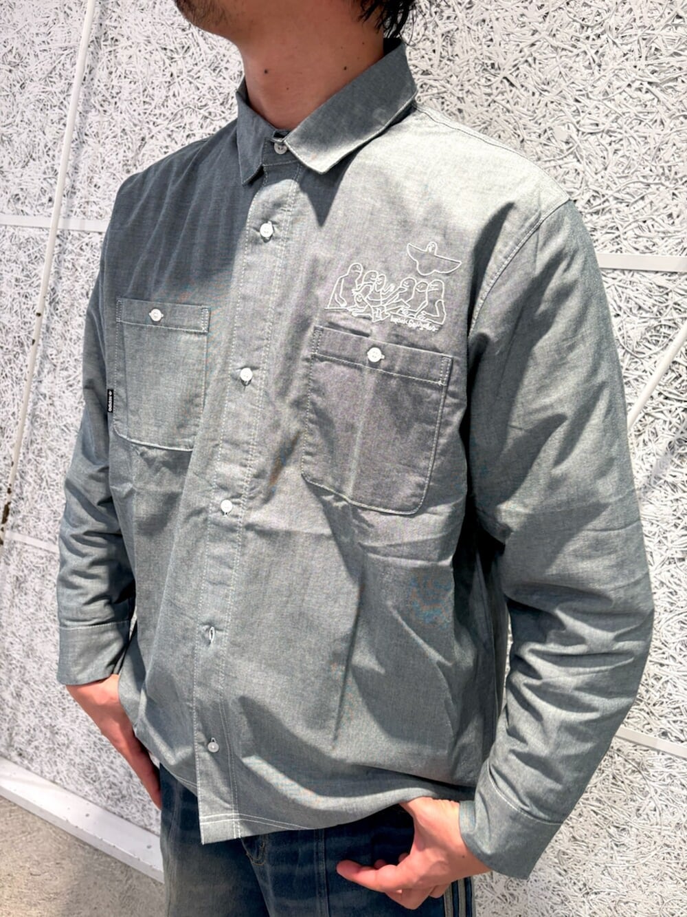 ブラック系のパーカー、グリーン系のトップス、ホワイト系のスニーカーを着用したメンズの冬コーディネートの4枚目の写真