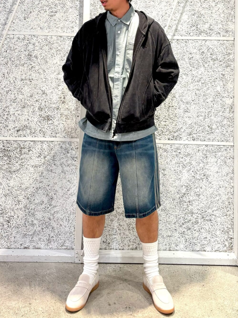 ブラック系のパーカー、グリーン系のトップス、ホワイト系のスニーカーを着用したメンズの冬コーディネートの2枚目の写真