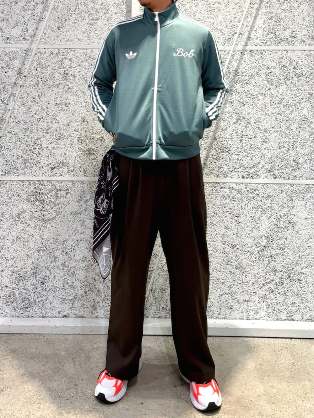 グリーン系のトップス、ホワイト系のスニーカー、ブラック系のバンダナ/スカーフを着用したメンズの冬コーディネートの2枚目の写真