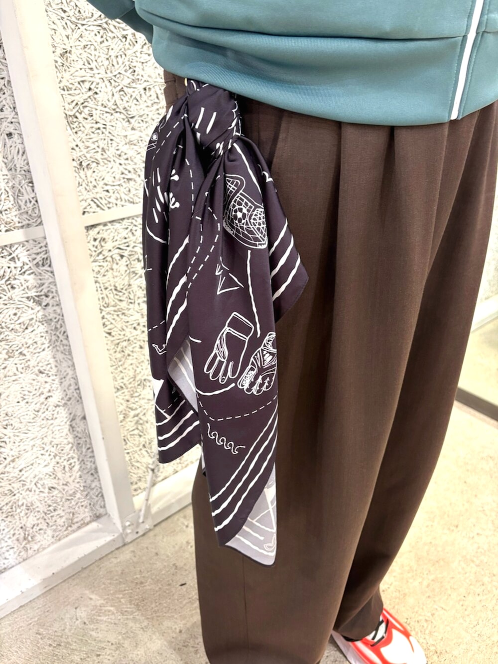 グリーン系のトップス、ホワイト系のスニーカー、ブラック系のバンダナ/スカーフを着用したメンズの冬コーディネートの5枚目の写真