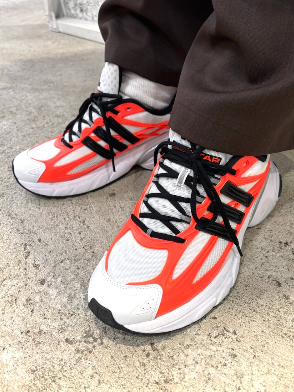 グリーン系のトップス、ホワイト系のスニーカー、ブラック系のバンダナ/スカーフを着用したメンズの冬コーディネートの6枚目の写真