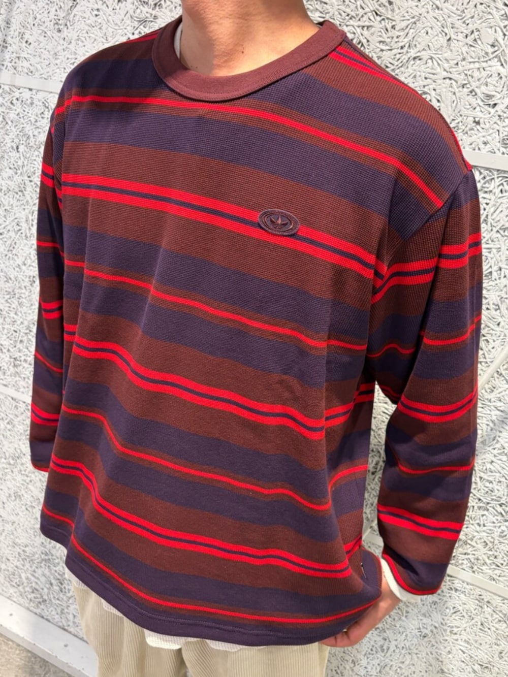 レッド系のTシャツ/カットソー、ブラック系のブルゾン、ブラック系のスニーカーを着用したメンズの冬コーディネートの3枚目の写真