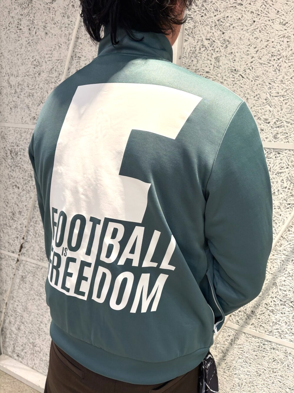 グリーン系のトップス、ホワイト系のスニーカー、ブラック系のバンダナ/スカーフを着用したメンズの冬コーディネートの4枚目の写真