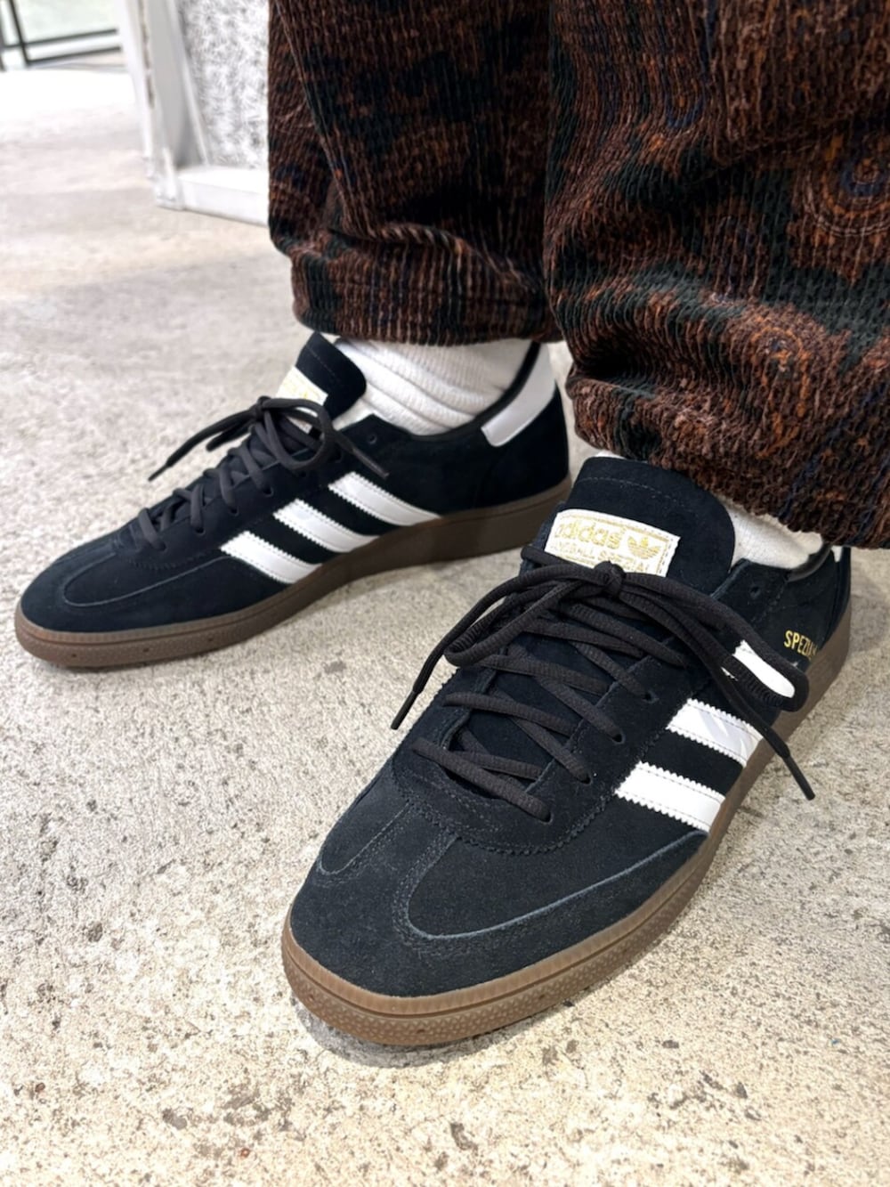 ブラック系のデニムジャケット、ブラック系のスニーカーを着用したメンズの冬コーディネートの4枚目の写真