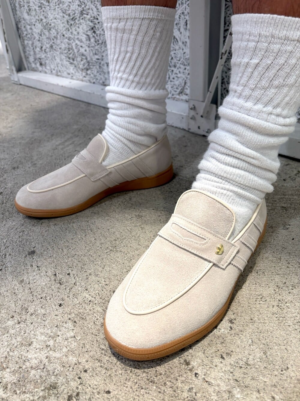 ブラック系のパーカー、グリーン系のトップス、ホワイト系のスニーカーを着用したメンズの冬コーディネートの6枚目の写真