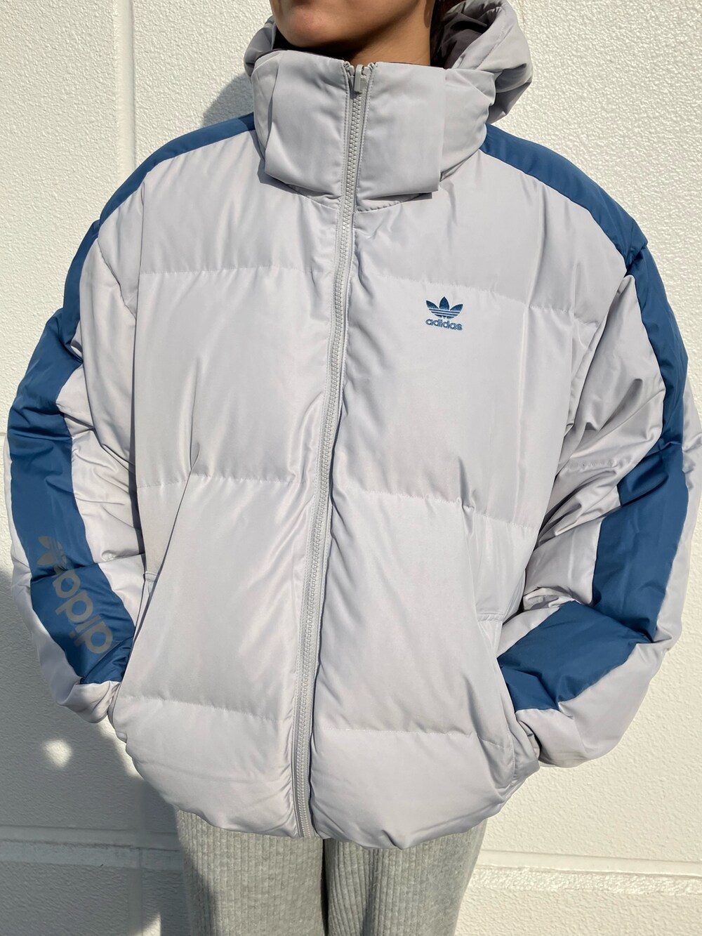 ブルー系のダウンジャケット/コート、ホワイト系のスニーカーを着用したレディースの冬コーディネートの3枚目の写真