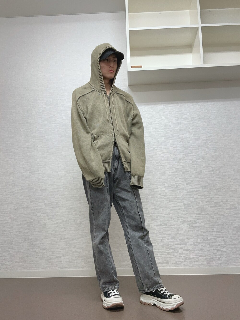 ブラック系のデニムパンツ、ブラック系のスニーカー、グリーン系のパーカーを着用したメンズの冬コーディネートの2枚目の写真