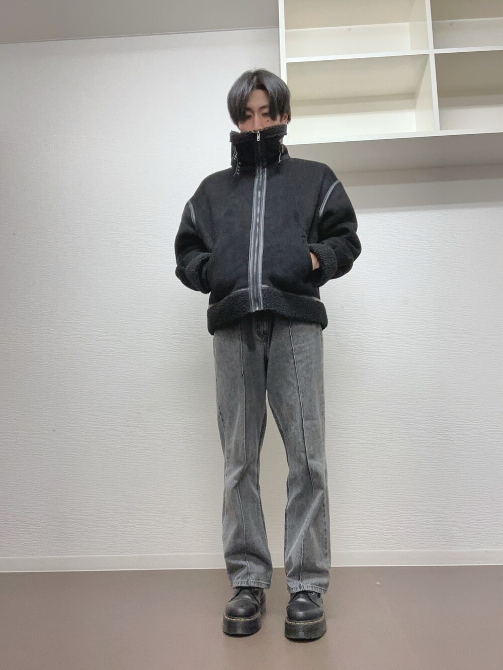 ブラック系のデニムパンツ、ブラック系のブーツ、ブラック系のムートンコートを着用したメンズの冬コーディネートの2枚目の写真