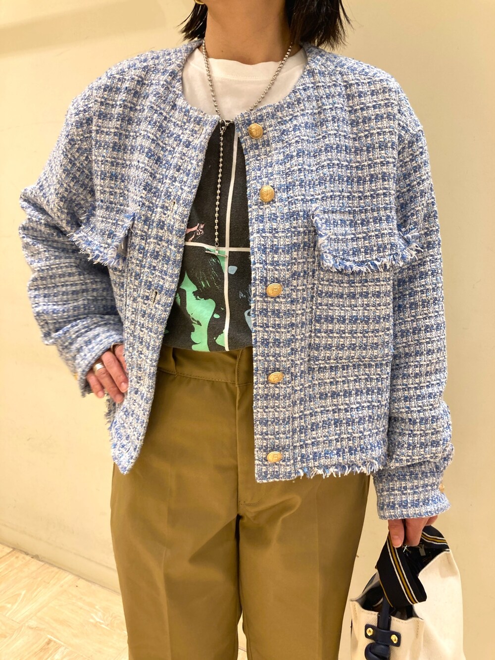 ブルー系のトートバッグ、ベージュ系のその他パンツ、ブルー系のノーカラージャケットを着用したレディースの春コーディネートの3枚目の写真